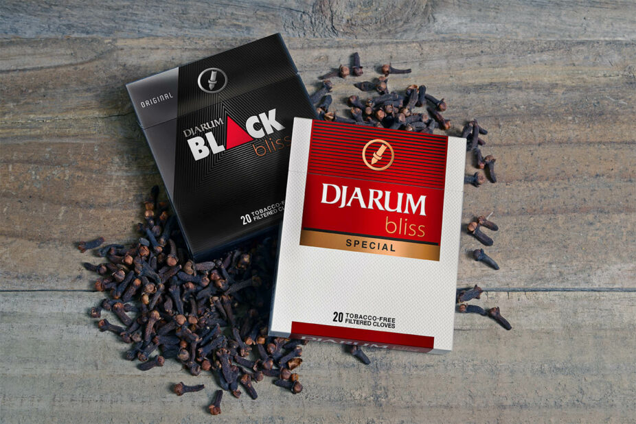 pack of djarum black bliss original and pack of djarum special bliss laying on a pile of clove on top of a table